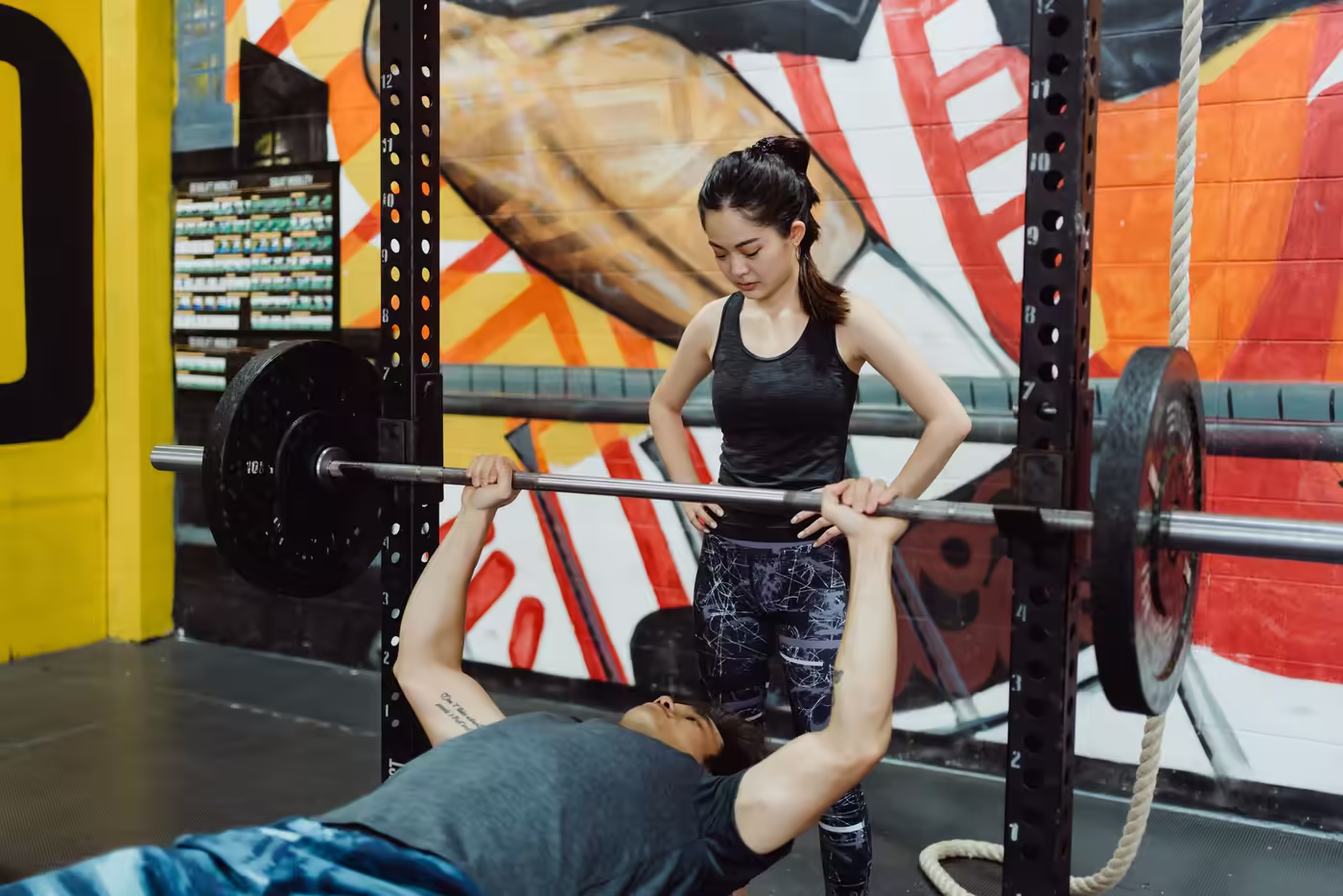 A coach spotting a barbell bench press