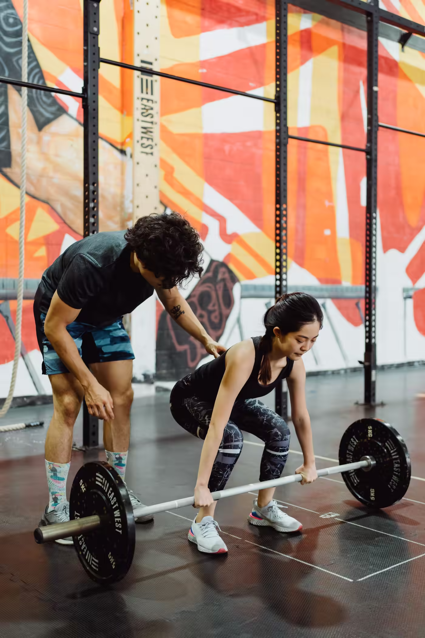 A coach cueing a lifter through a deadlift set-up