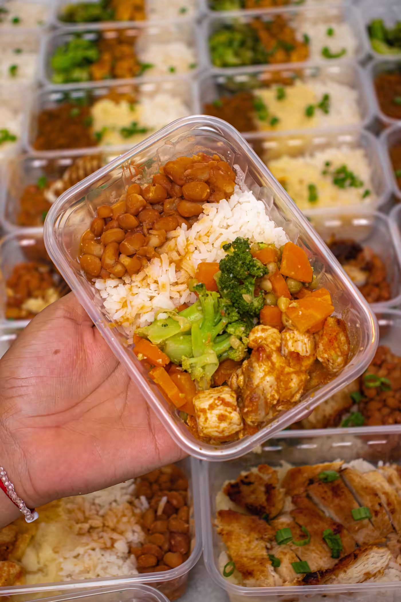 A meal-prep container of chicken, rice, chickpeas, broccoli and carrots